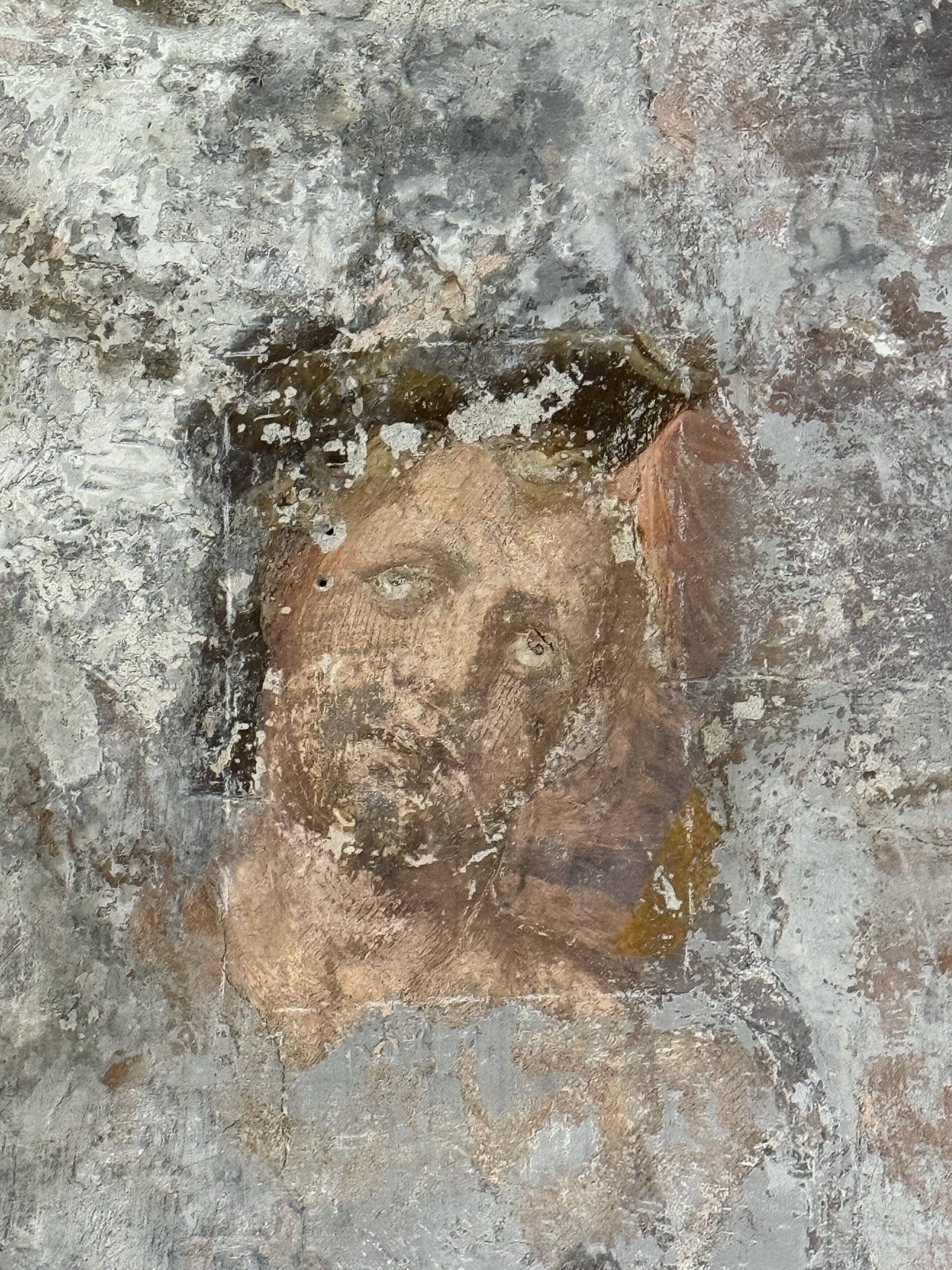 Particolare del volto di Cristo crocefisso emerso dal restauro, riquadro centrale degli affreschi di Pellegrino Tibaldi a Claino