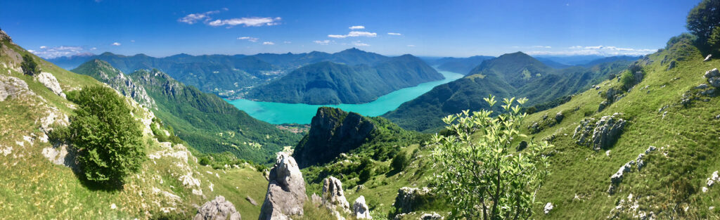 Panorama del Lago Ceresio visto dalle Cime di Noga, in Valsolda, con le acque turchesi del lago tra le montagne delle valli