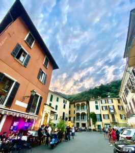 Piazza Roma a San Mamete al tramonto, con tavolini e vista sul borgo, Valsolda