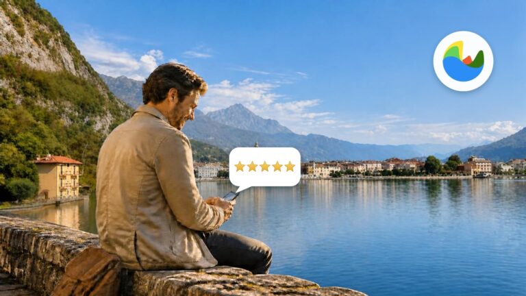 Un turista seduto su un muretto di pietra affacciato sul lago sorride mentre compila il questionario sul telefono; sopra il telefono compaiono cinque stelle
